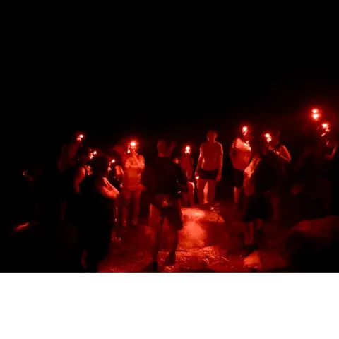 tourists with guides in twilight rainforest nature walk